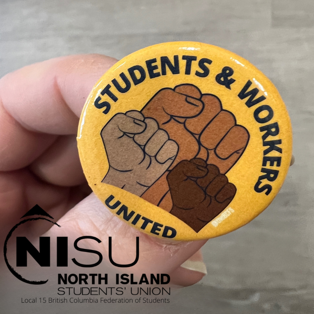 A hand holds a yellow button that reads Students and Workers United with three fists.